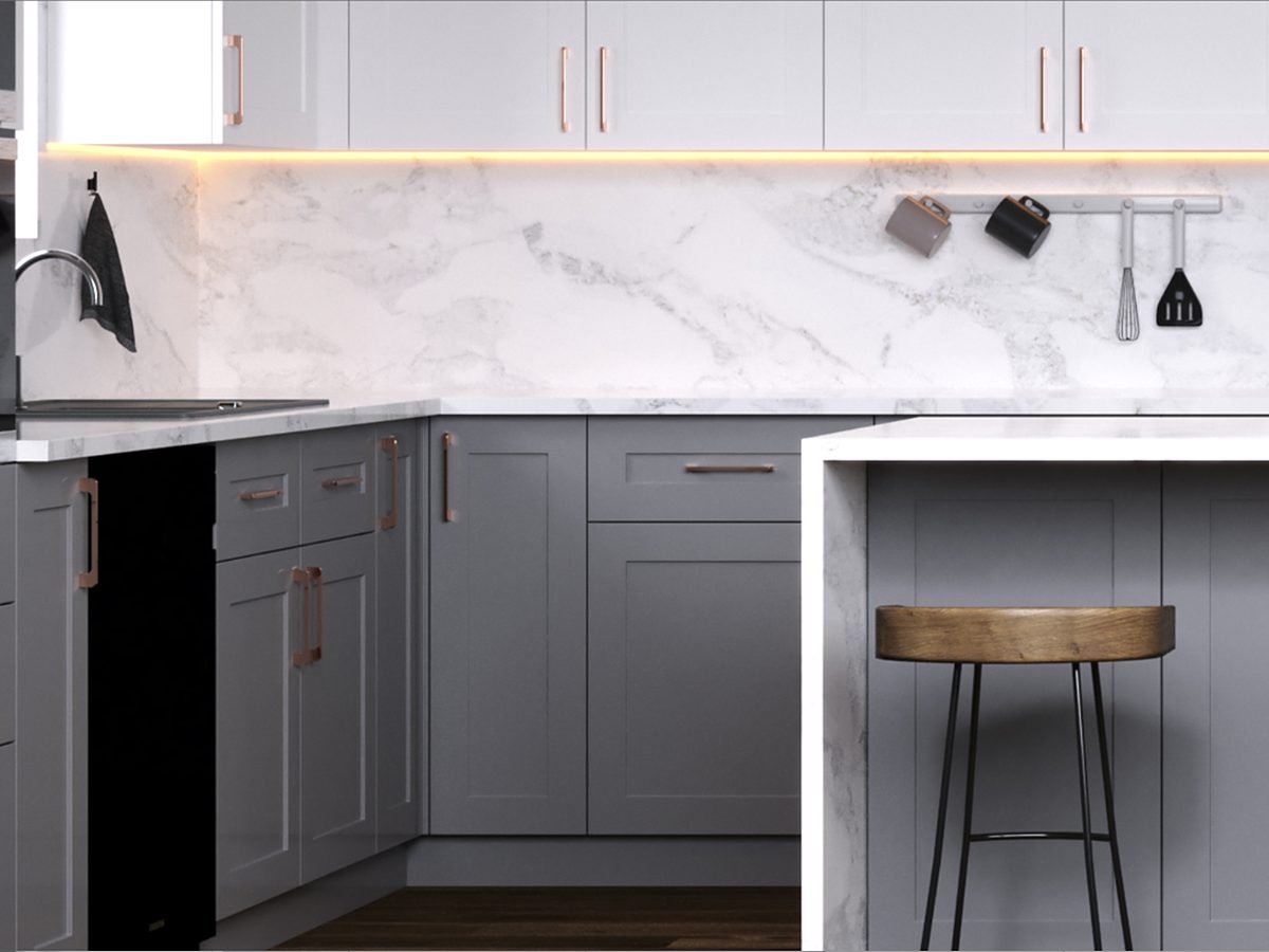 J&K Cabinetry gray shaker kitchen with white uppers and a marble-look backsplash — manufacturer photo