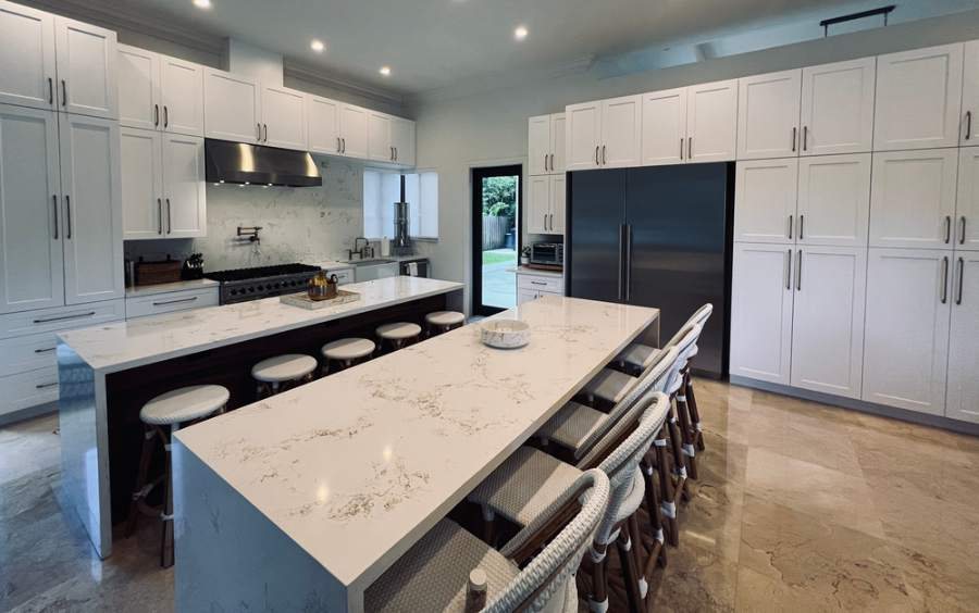 Adornus white kitchen with marble-look counters and a centre island — manufacturer photo
