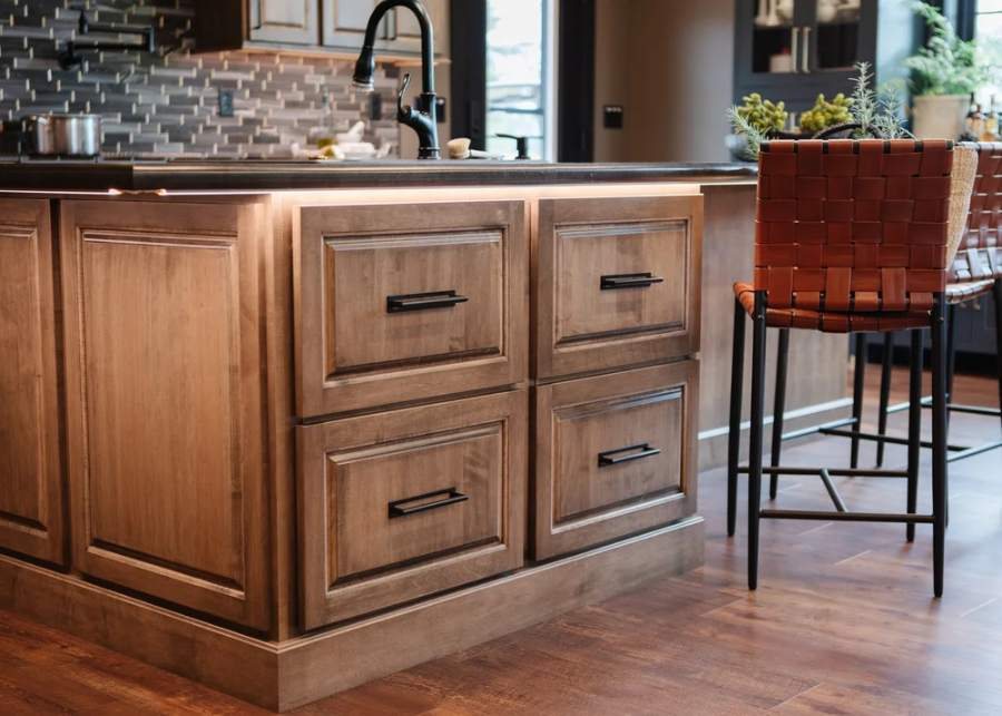 Great Northern stained maple island with a tile backsplash — manufacturer photo