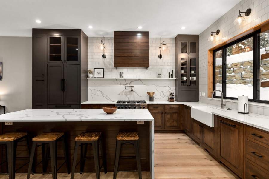 Plain & Fancy rustic kitchen in dark wood with a marble backsplash and black accents — manufacturer photo