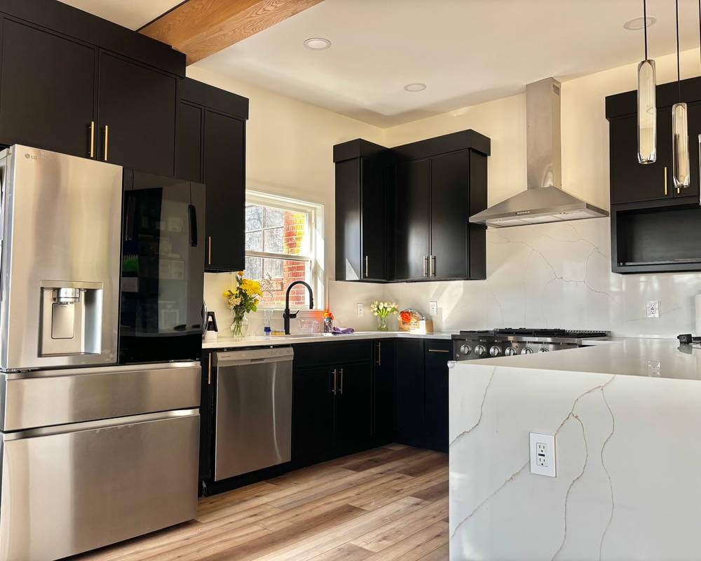 WoodConcept Profile Caviar black kitchen with a quartz waterfall island — manufacturer photo