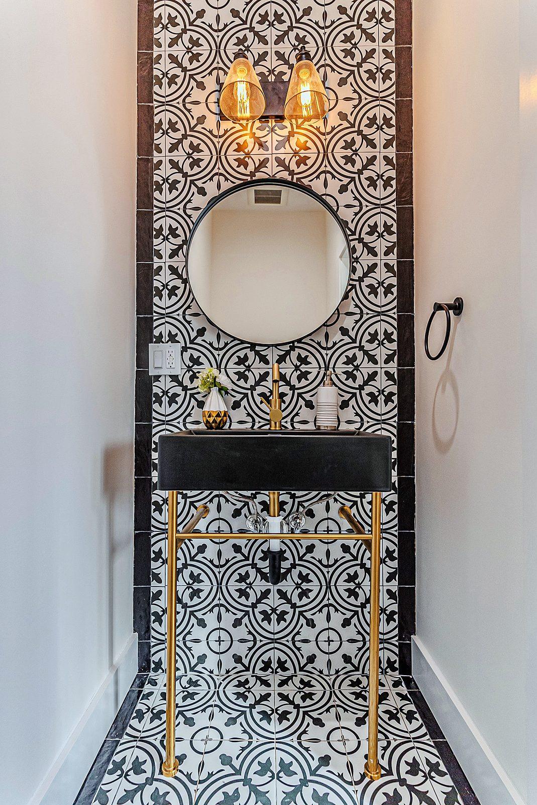 Powder room with black vanity and patterned tile