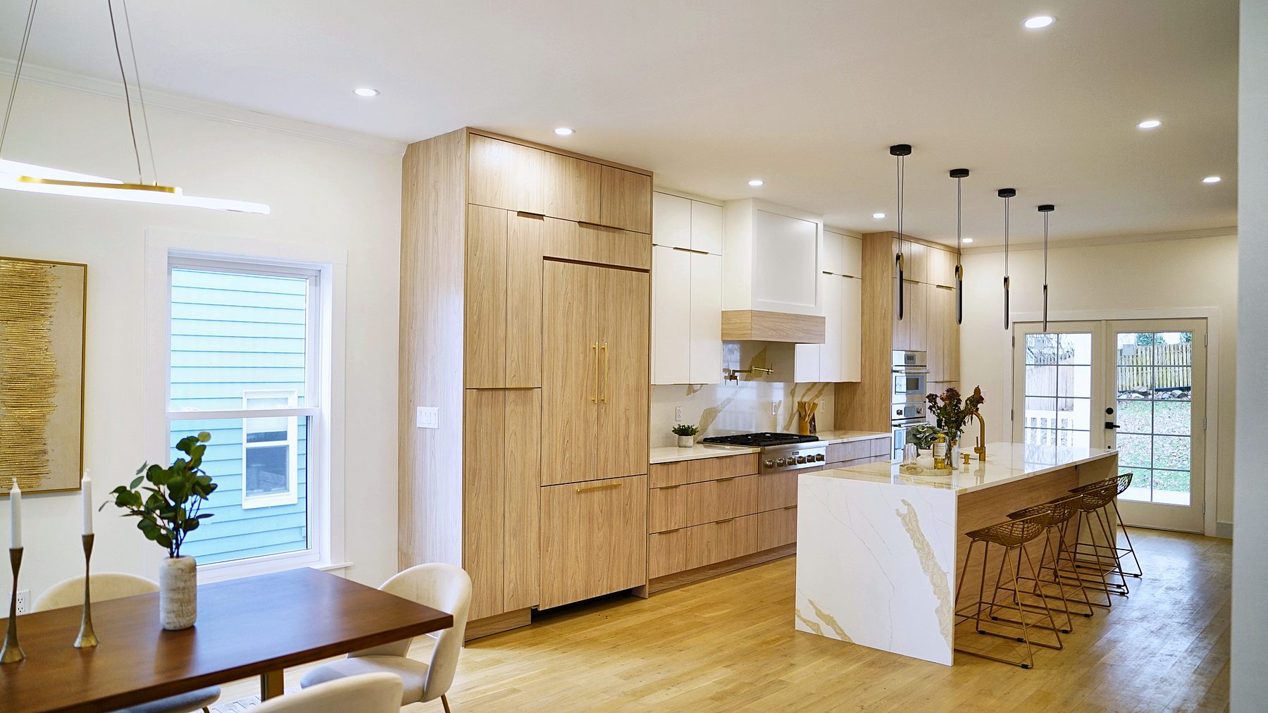 Matte white and rift oak slab kitchen with Calacatta waterfall island
