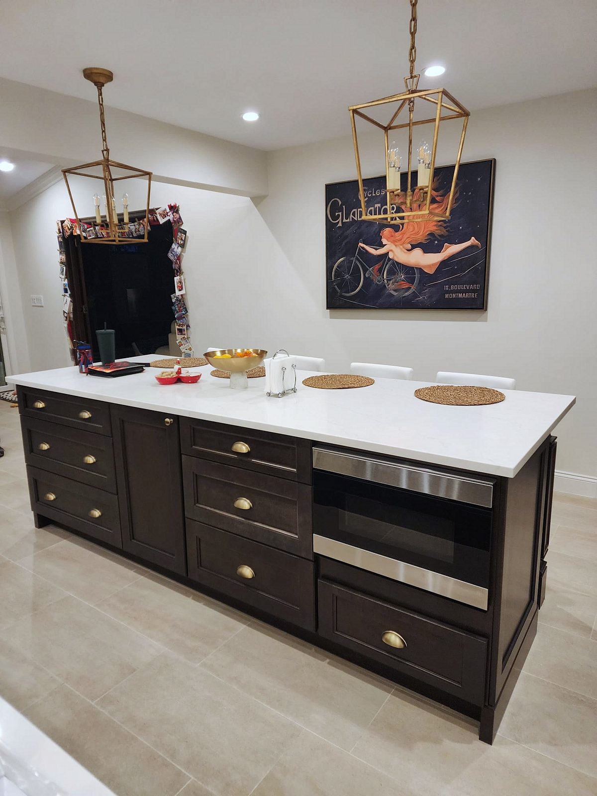 Island with a farmhouse sink, microwave and brass cup pulls — Fabuwood Fusion kitchen in Dove with a Kona island and brass lanterns