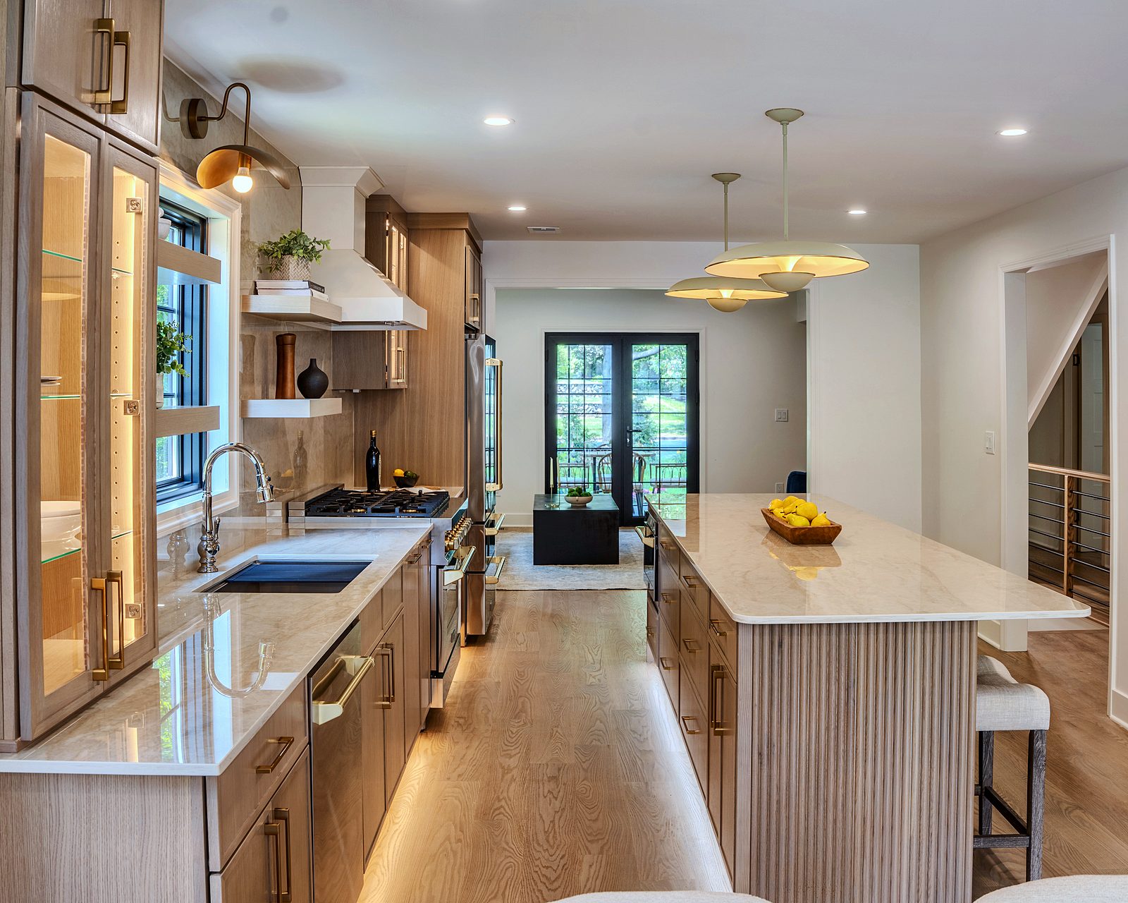 Long run of Desert Oak cabinets with glass uppers and island seating