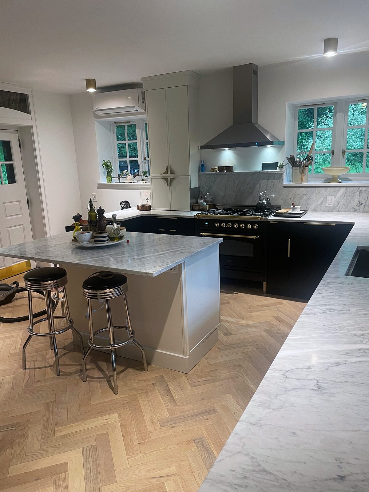 Fabuwood Luna door, matte black perimeter and pantry wall (archive label) — Fabuwood Luna kitchen in matte black with a Dove island and a herringbone floor