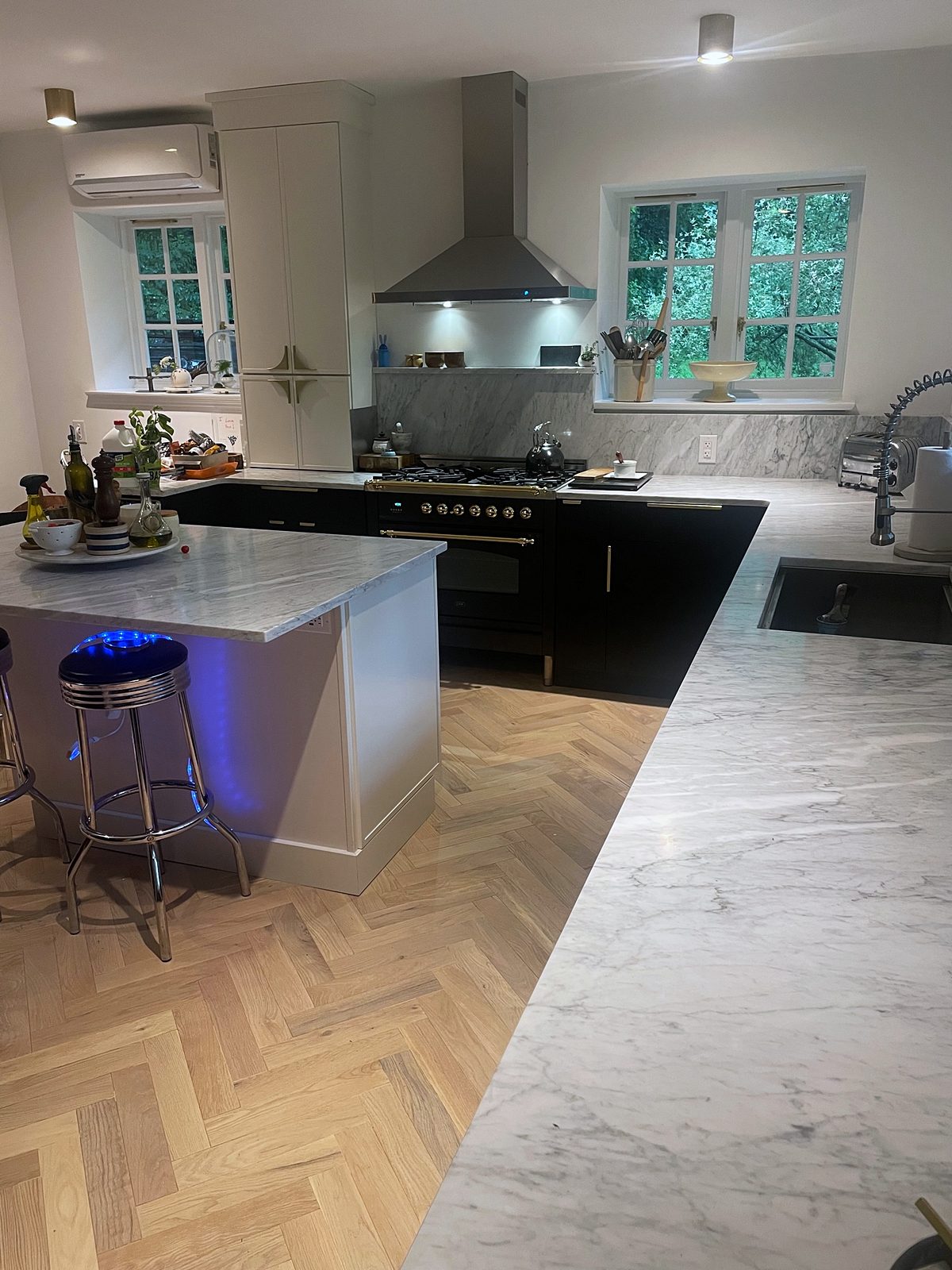 Luna Dove island with a gray-veined marble-look top — Fabuwood Luna kitchen in matte black with a Dove island and a herringbone floor