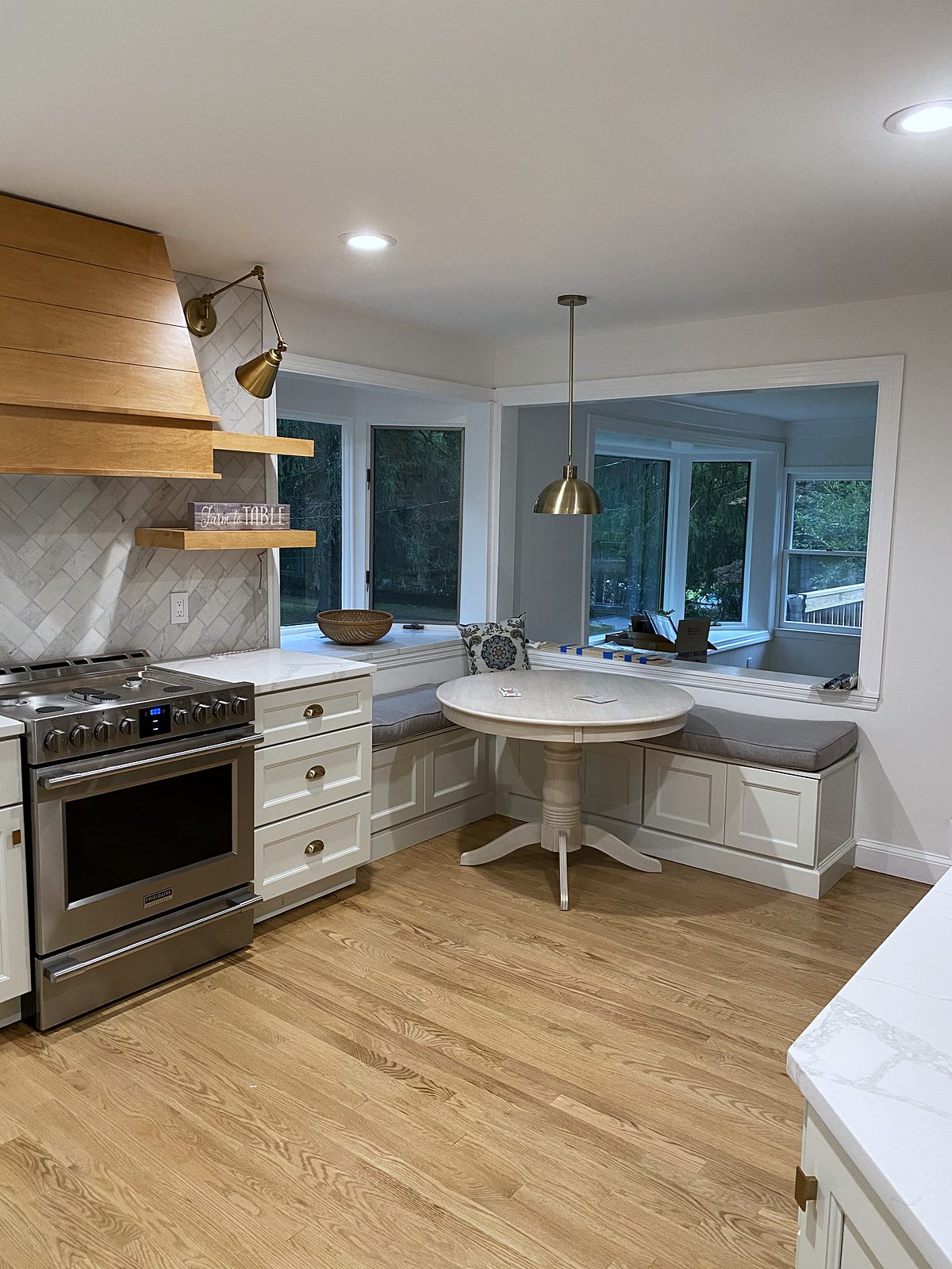 Fabuwood Nexus door, Frost (archive label) — Fabuwood Nexus Frost kitchen with a white-oak hood and a breakfast nook