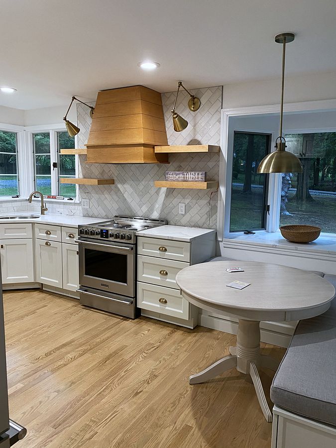 Fabuwood Nexus Frost kitchen with a white-oak hood and a breakfast nook