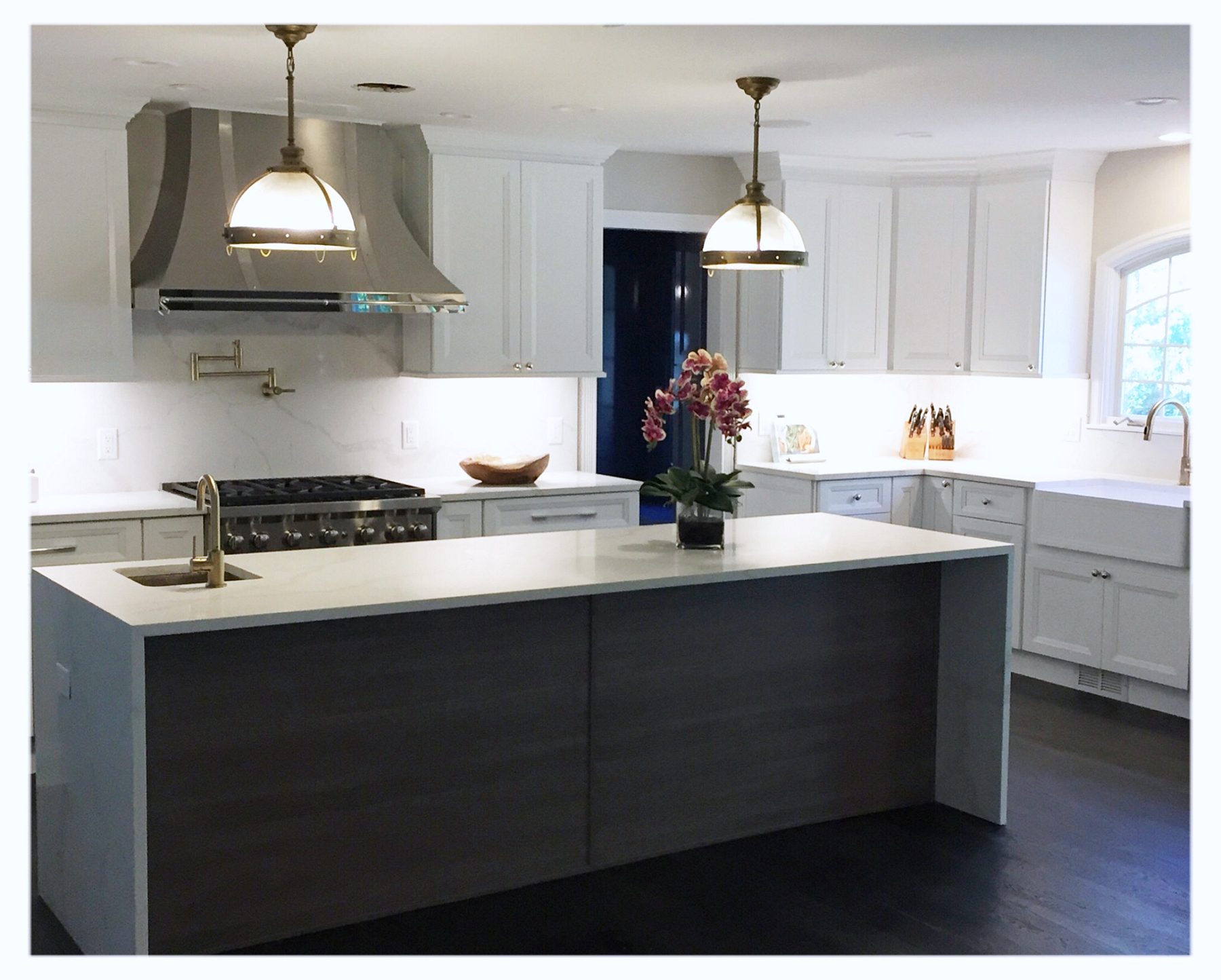 Fabuwood Onyx Frost kitchen with a Cobblestone island and brass dome pendants