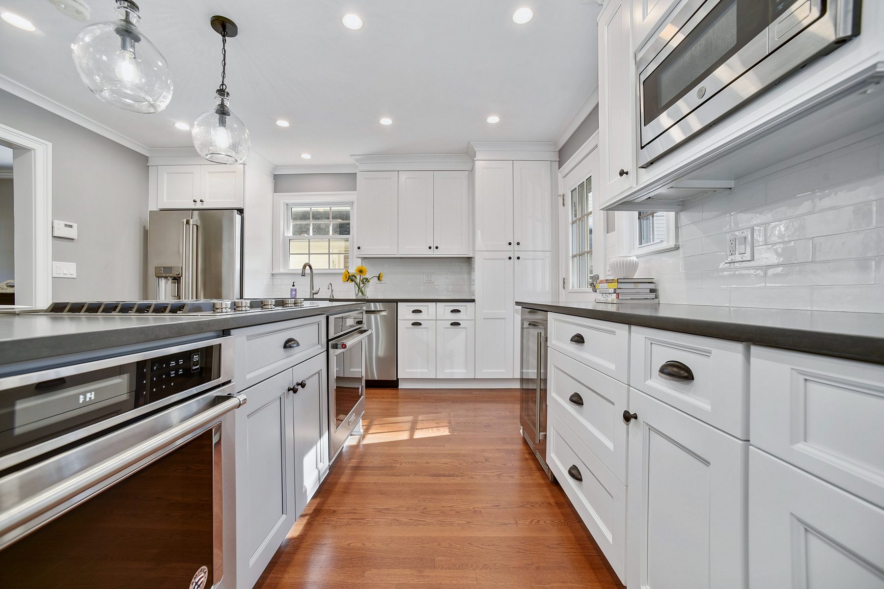 Fabuwood white shaker kitchen with a gray island and glass pendants in Maplewood, NJ