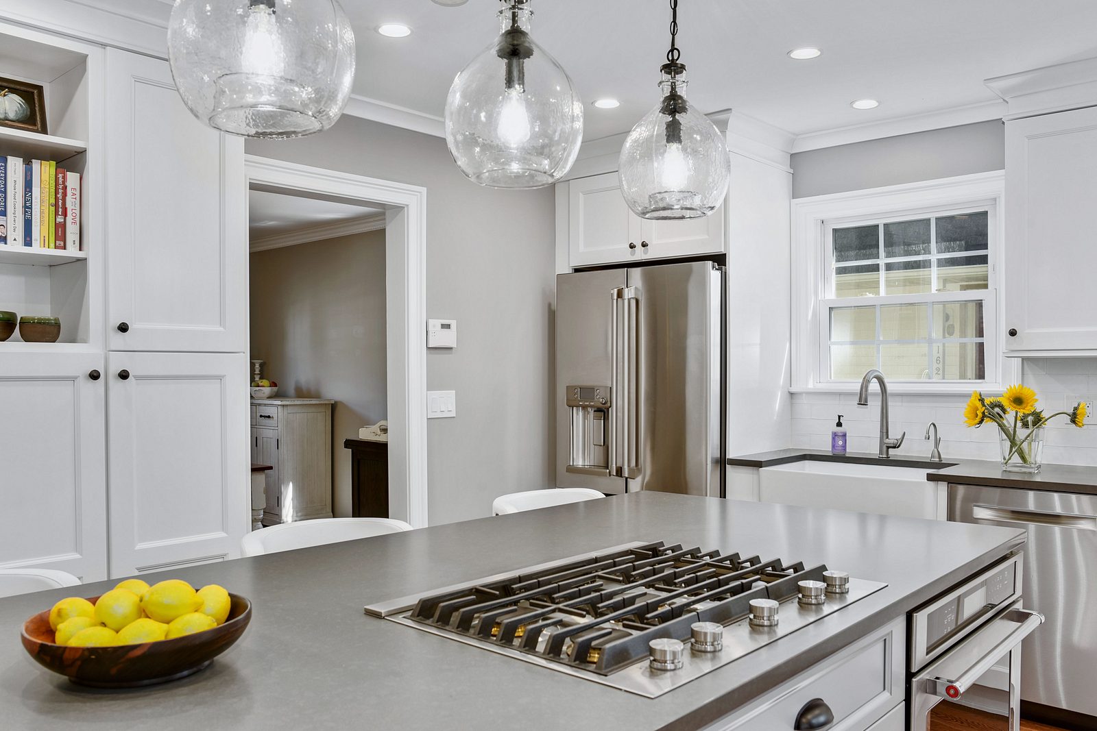Fabuwood white shaker perimeter (archive label) — Fabuwood white shaker kitchen with a gray island and glass pendants