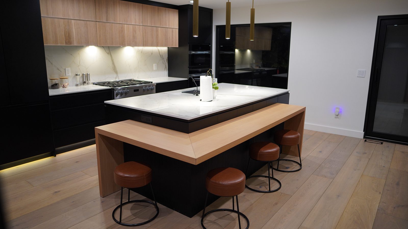 The island and the cooking wall with its full-height marble-look backsplash