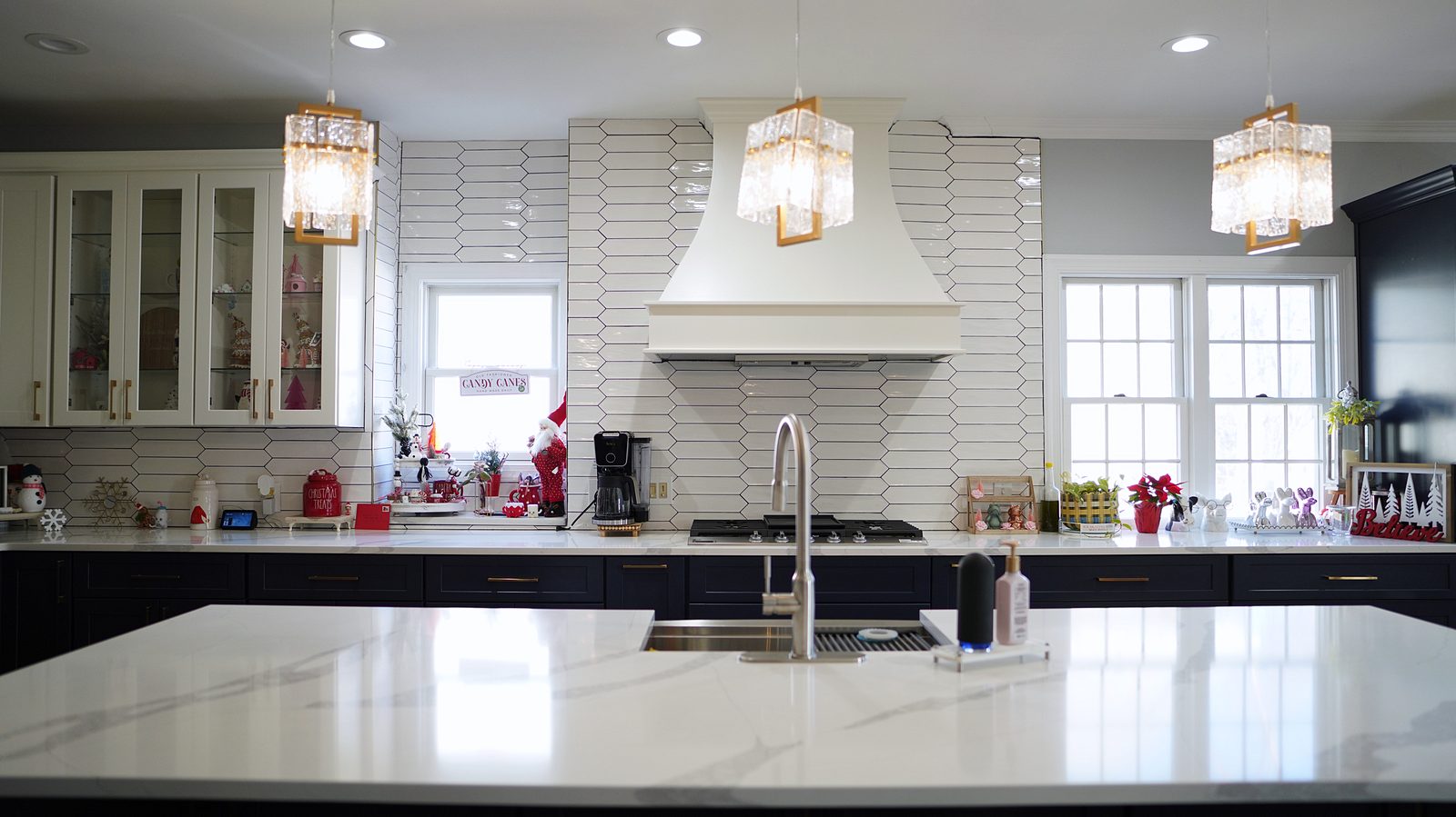 White custom hood between glass-mullion uppers over the picket tile