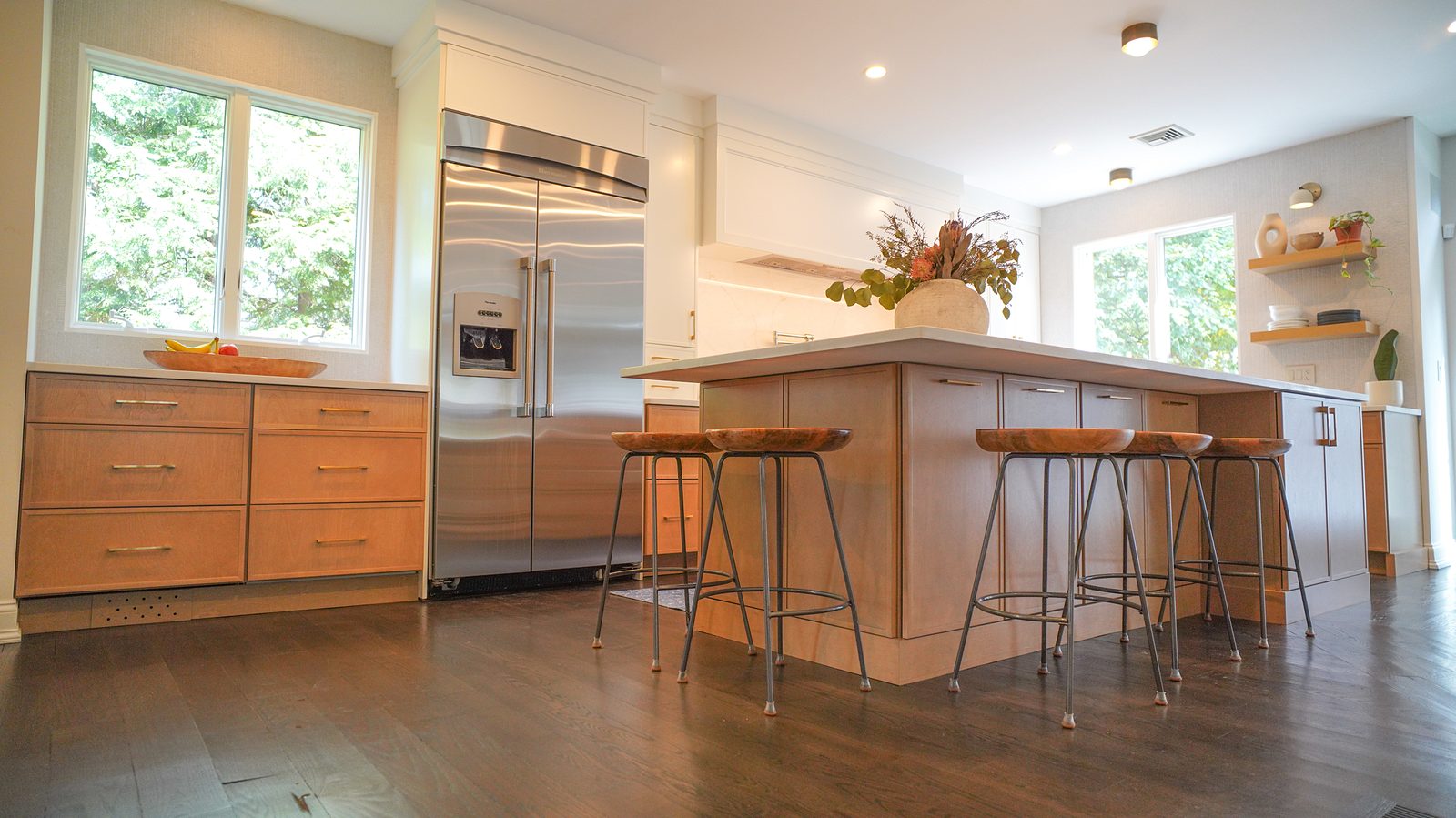 Island and stools with the oak floating shelves at the window behind