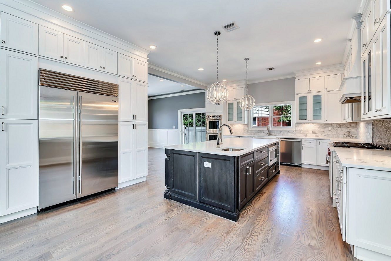 Crystal-and-glass globe pendants — White shaker kitchen with a long charcoal island in a two-story great room