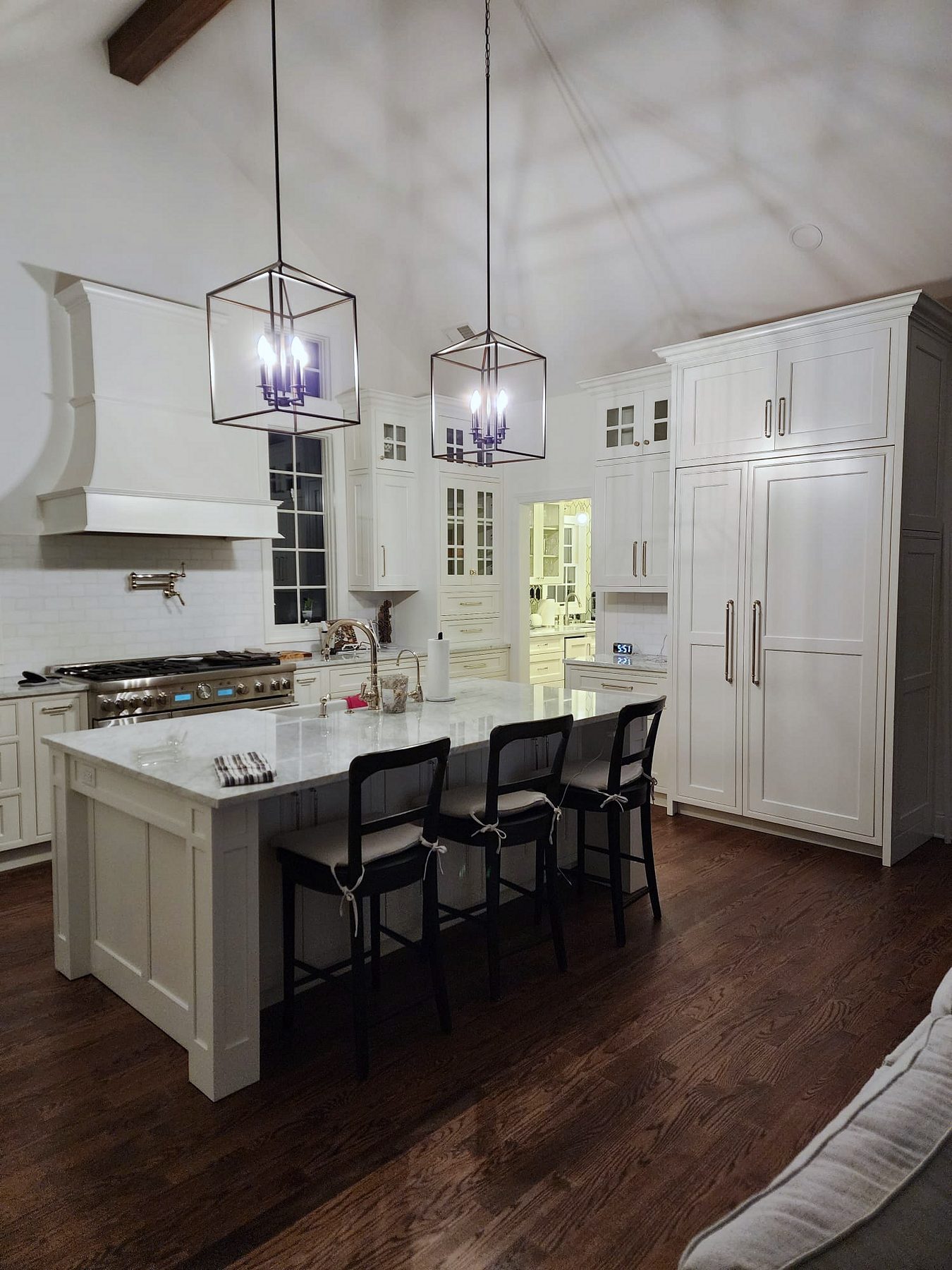 Shiloh Heritage beaded-inset kitchen under a vaulted ceiling with a curved hood