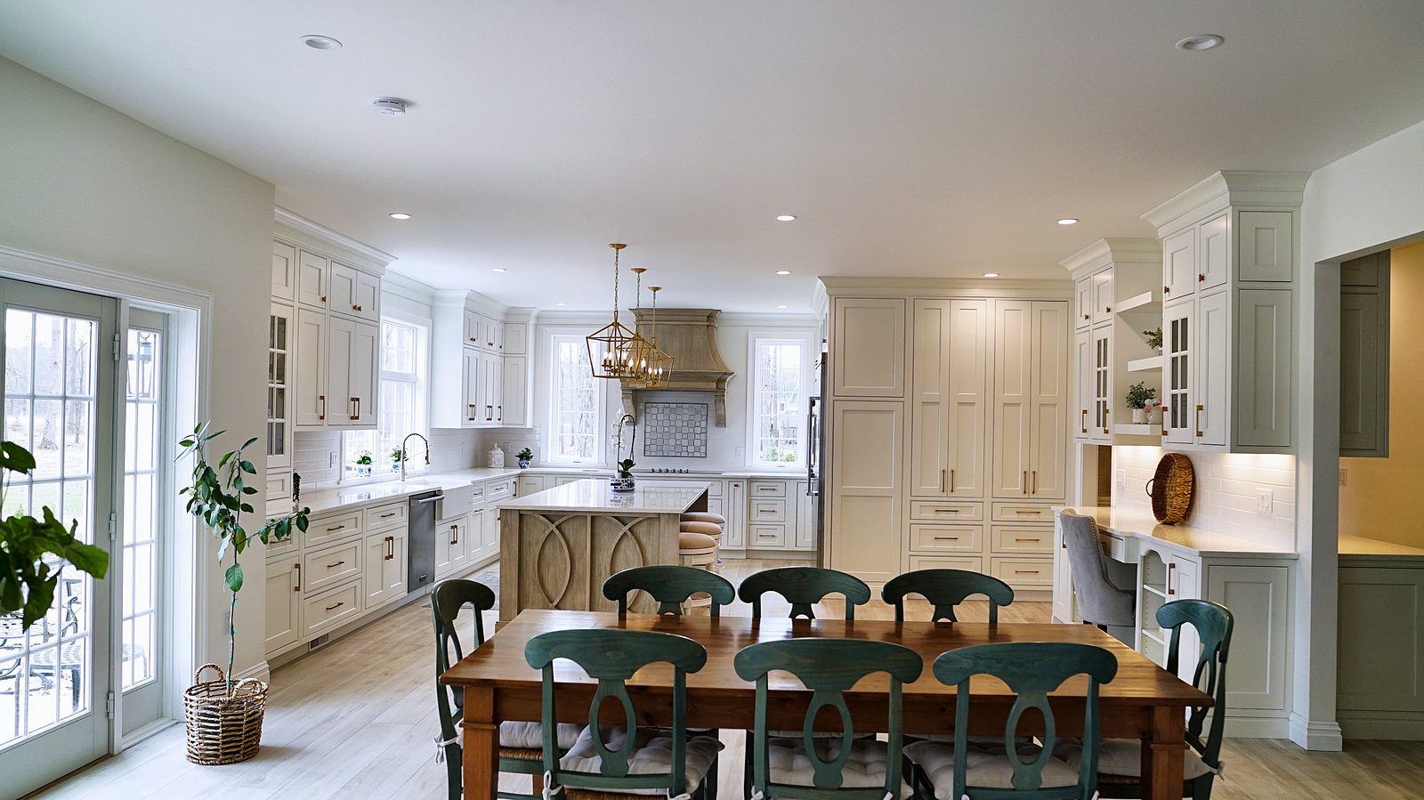 Dining table in front of the kitchen, island and hutch wall
