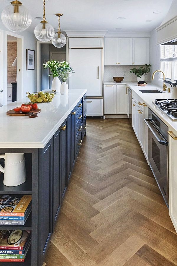 White kitchen with navy island and brass pulls