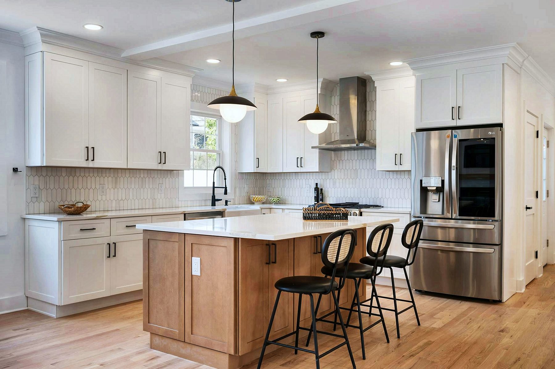 White shaker kitchen with oak island and black stools