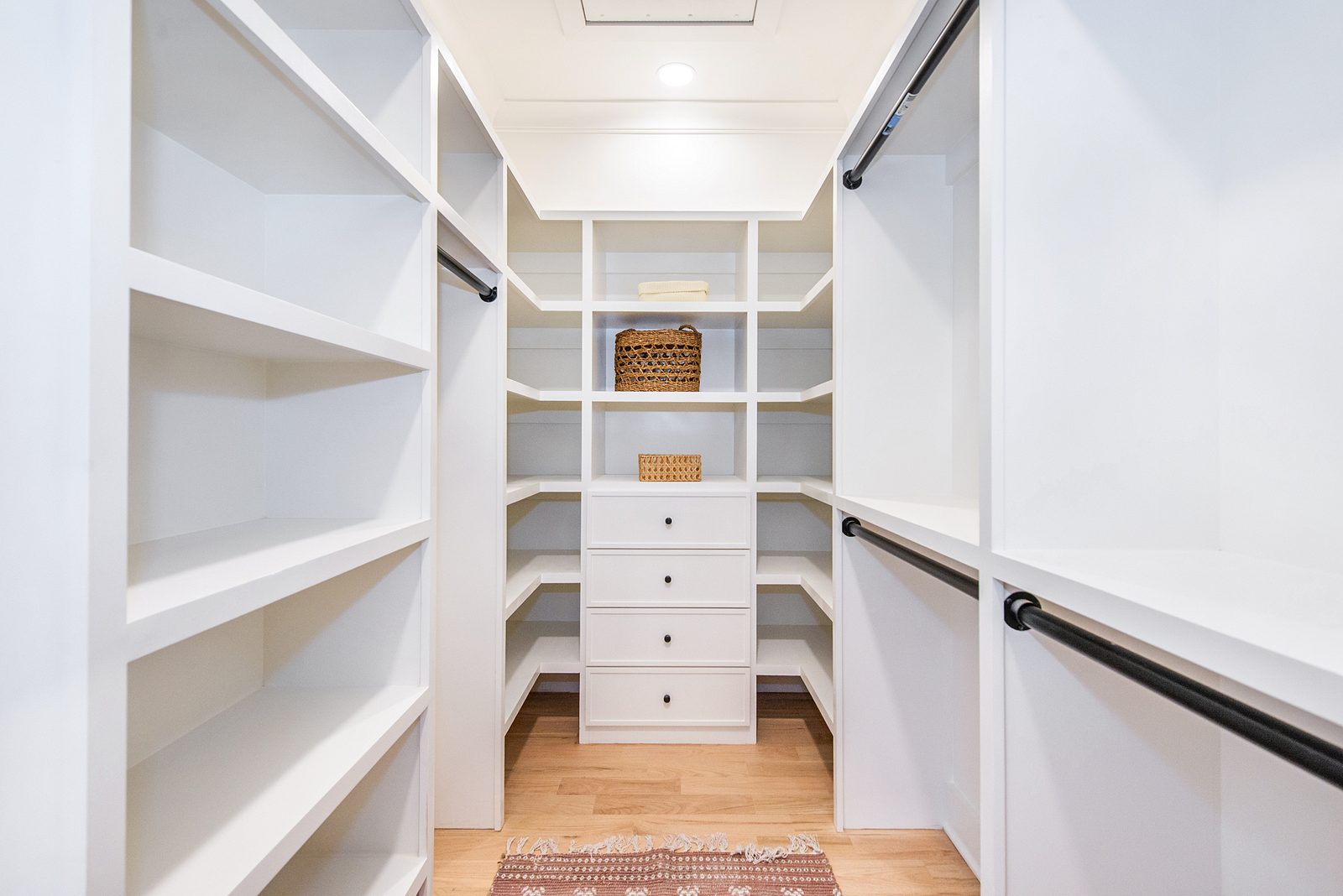 Walk-in pantry with open white shelving and a bank of drawers