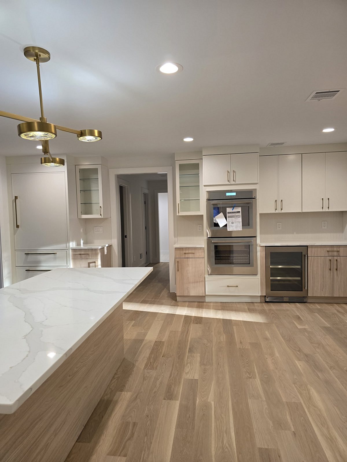 Tall run with wall ovens and the wine fridge, in white and driftwood