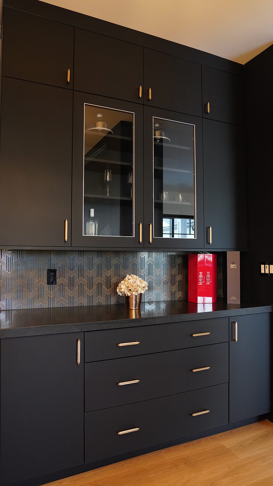 Black butler's pantry with glass uppers and brass pulls
