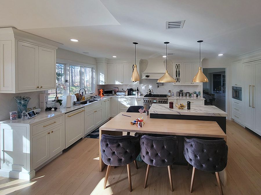 White shaker kitchen with a navy island, marble top and wine fridge