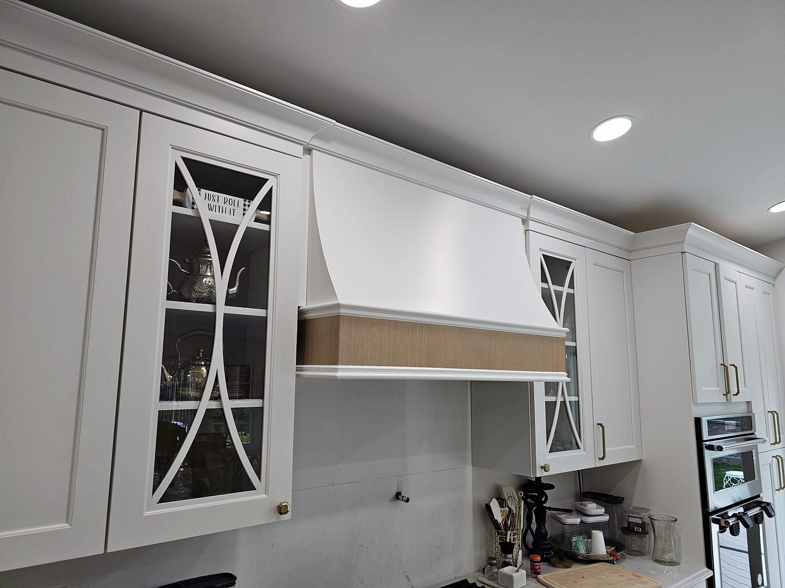 White shaker perimeter with X-mullion glass uppers — White shaker kitchen with X-mullion glass uppers and a stained wood island on turned legs